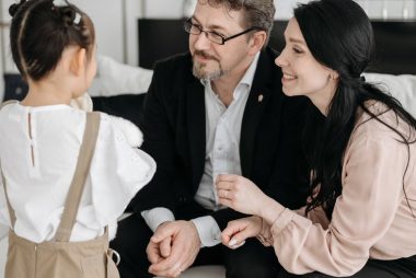 A joyful moment shared between parents and their child in a cozy indoor setting.